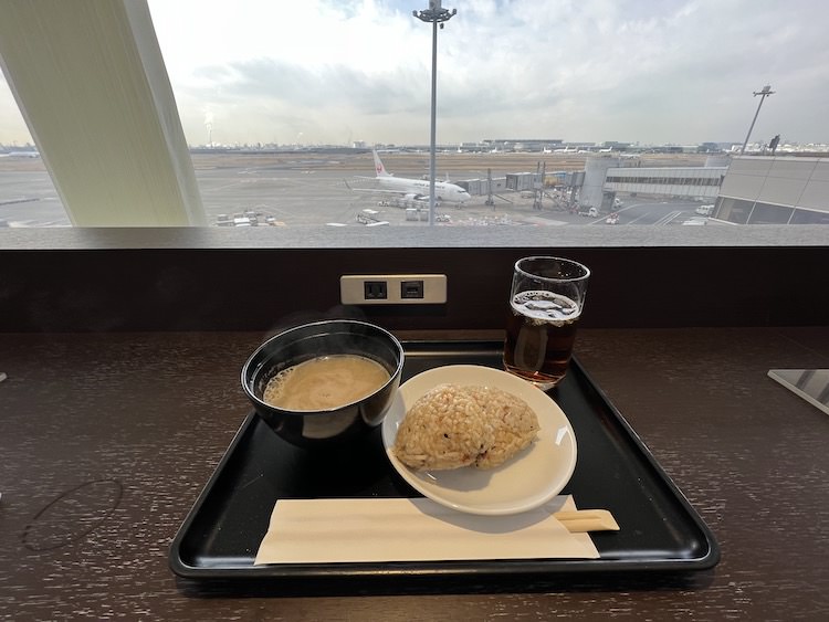 ▲飛行機を見ながらジューシーおにぎりとお味噌汁と烏龍茶をいただく